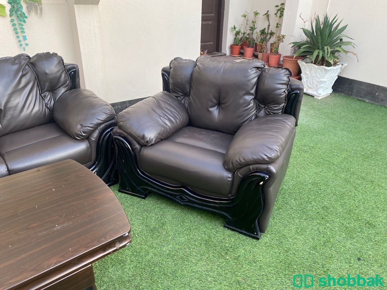 كنبات جلد اسود وطاولات بني غامق شباك السعودية